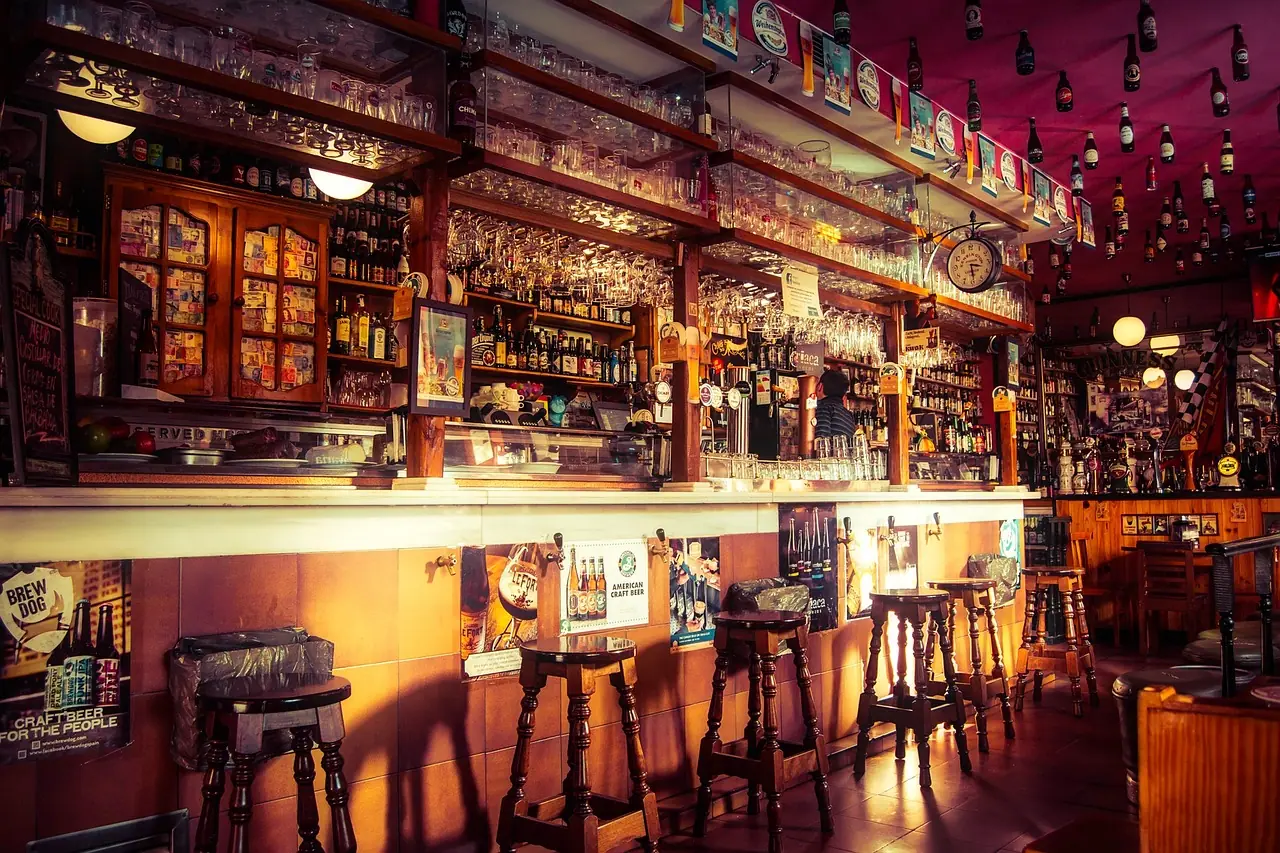 Comptoir de bar éclairé d'une lumière chaude, tabourets alignés