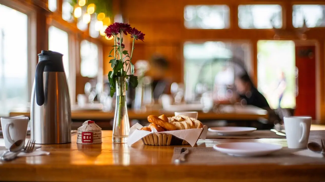 Table dressée dans une salle de restaurant chaleureuse, tout en bois