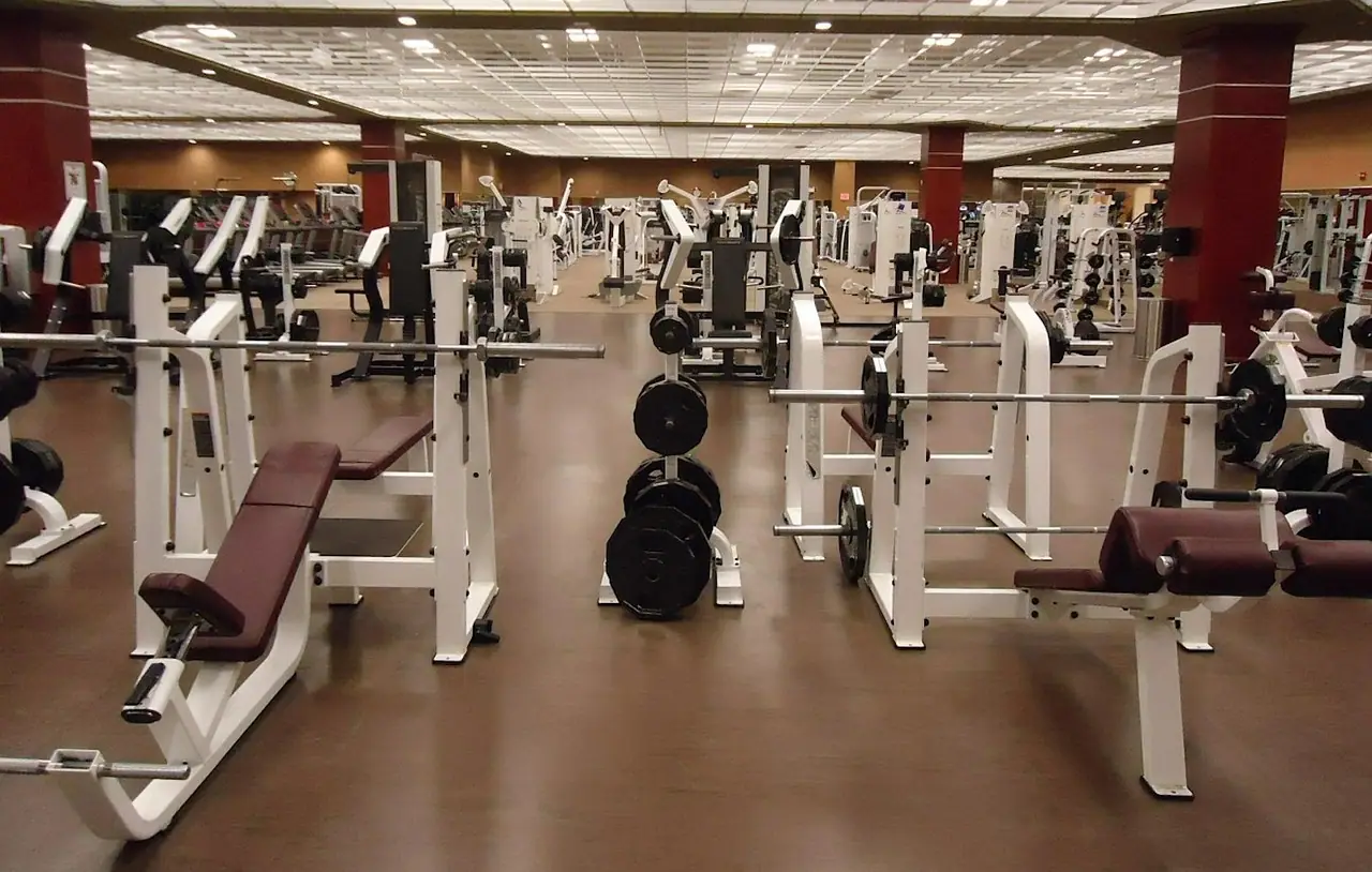 Salle de sport avec bancs de musculation et poids